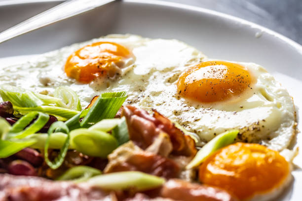 istock English Breakfast with eggs, bacon, beans and iyoung onion in white plate 1168425911