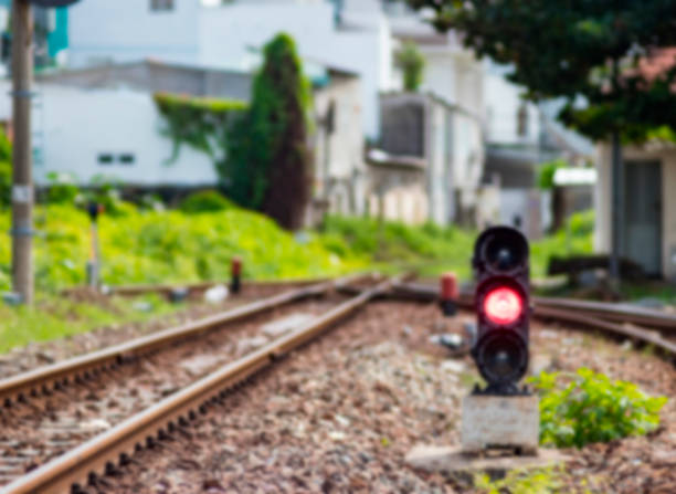The railway goes into the distance, and on the ground a semaphore with a red brake light. The whole picture is out of focus