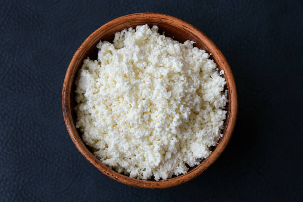 istock Cottage cheese in a brown bowl on a dark background. 1168427749