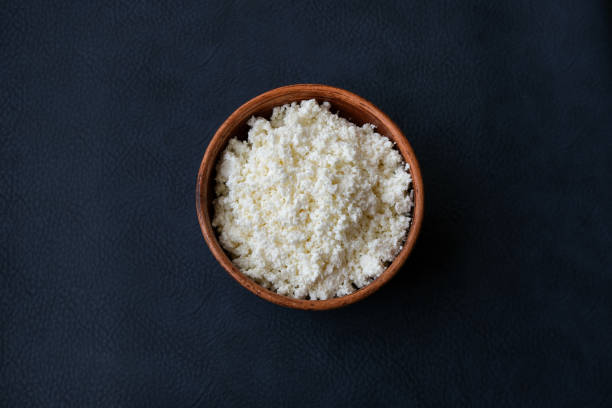 istock Cottage cheese in a brown bowl on a dark background. 1168427782