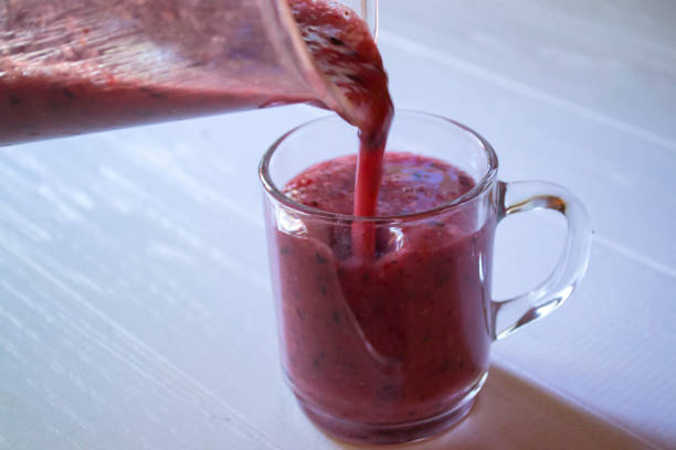 istock Pouring fruit smoothie in the glass cup. 1168430509