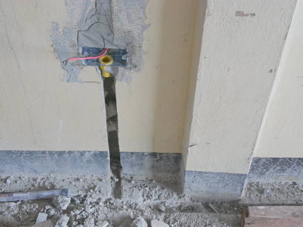 istock Electrical back box, conduit, and wires are installed, secured by cement, in a house wall getting ready for switches and sockets 1168431783
