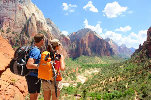 Hiking - hikers looking at view in Zion National park. People living healthy active lifestyle dong hike in beautiful nature landscape to Observation Point near Angles Landing, Zion Canyon, Utah, USA.