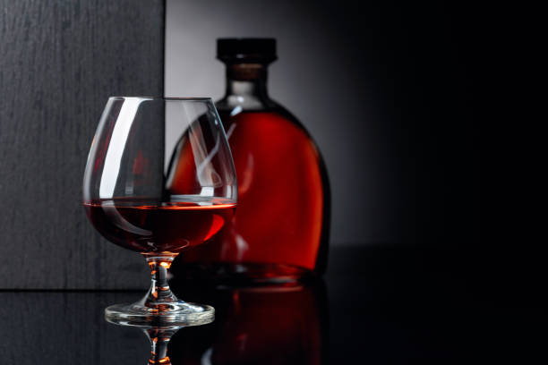 istock Glass and bottle of brandy on a black reflective background. 1168440605