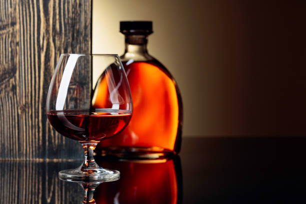 istock Glass and bottle of brandy on a black reflective background. 1168440607