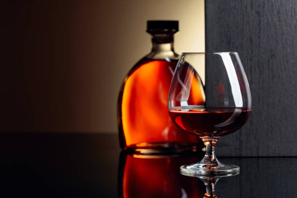 istock Glass and bottle of brandy on a black reflective background. 1168440620