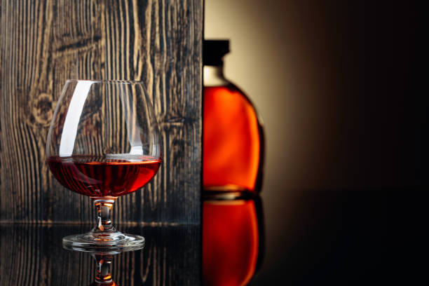 istock Glass and bottle of brandy on a black reflective background. 1168440626