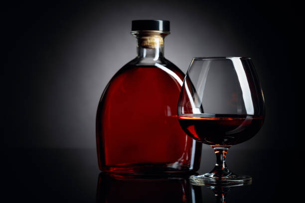istock Glass and bottle of brandy on a black reflective background. 1168440665