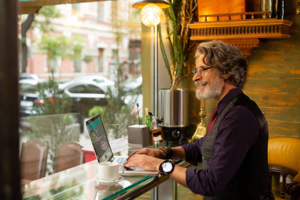 istock Smiling man working sitting in a coffee shop. 1168443746