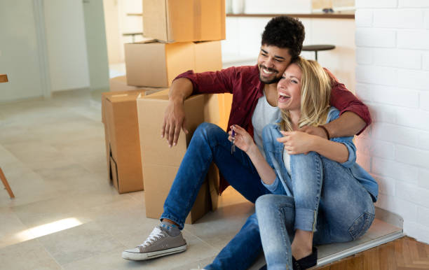 istock Young couple unpacking cardboard boxes at new home moving in concept 1168444725