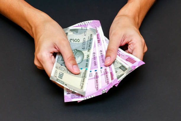 istock Female hands holding new indian 500 and 2000 rupees banknotes. 1168445699