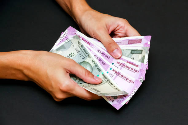 istock hands holding brand new indian 500 and 2000 rupees 1168445702