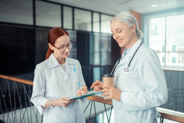 istock Smiling Caucasian female doctor writing on the clipboard 1168445769
