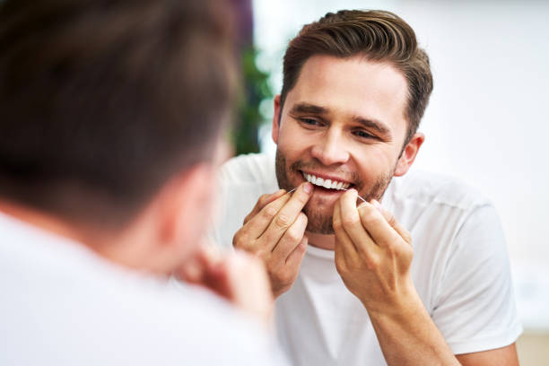 istock Adult man flossing teeth in the bathroom 1168445773
