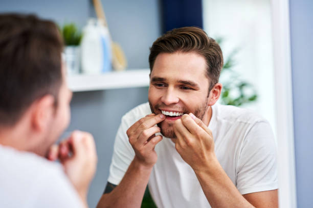 istock Adult man flossing teeth in the bathroom 1168445879