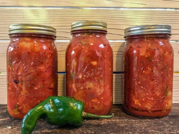 istock Row of preserved tomatoes in canning jars 1168445888