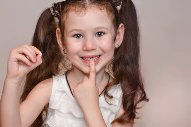 la bambina di 6 anni tiene un dente in mano, che ha perso - 6 7 years little girls child portrait foto e immagini stock