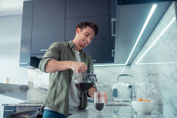 istock Handsome man pouring coffee into cup in the morning 1168446158