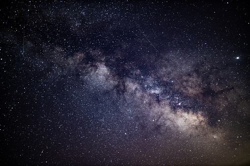 Beautiful abstract view of the core of the Milky Way Galaxy in all its beauty as seen on a clear cloudless dark night during summer in Northern Hemisphere from Europe. Long exposure for 30 seconds, shot on Canon EOS R full frame system with 35mm prime lens for highest quality. Cold white balance applied to emphasise the space like feel.