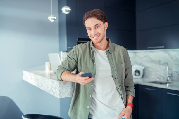 istock Dark-eyed young man smiling after reading message 1168446947