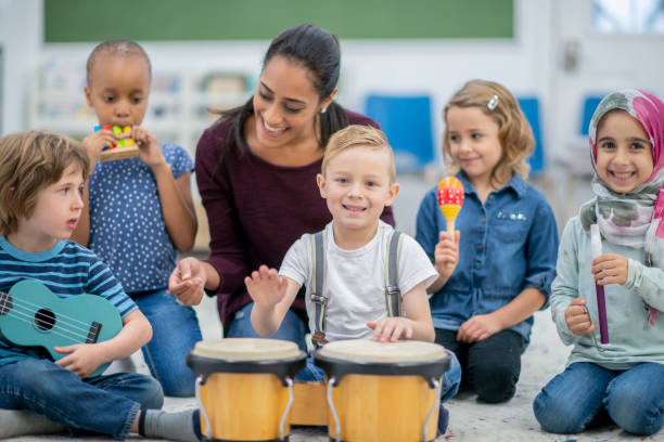 istock Little boy looks into camera as he plays the bongos 1168447350