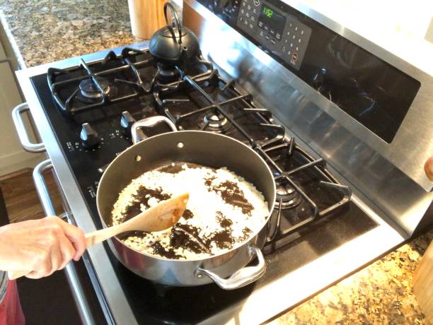 istock Sauteing onions in large pan on stove top 1168448106