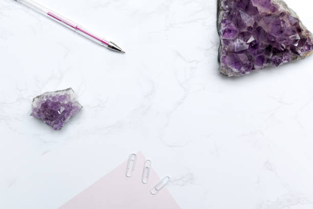 istock Purple themed stationary set with notebook and pen on a modern marble desk 1168448127