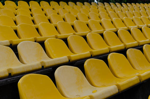 istock Rows of empty plastic yellow chairs at the stadium. Outdoors 1168448584