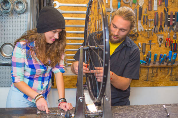 Young couple repairing bicycle in the workshop