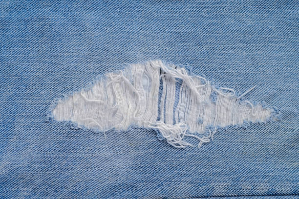istock tear of denim texture with a hole and threads showing 1168450703