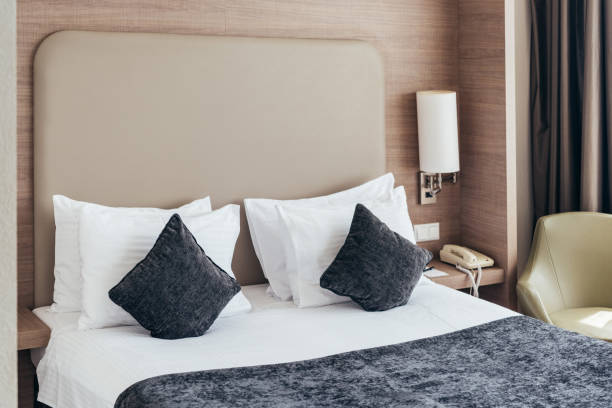 istock bed with pillows and cushions in cozy hotel room 1168451143