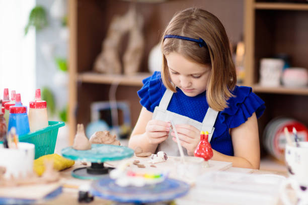istock Child at pottery wheel. Kids arts and crafts class 1168451954