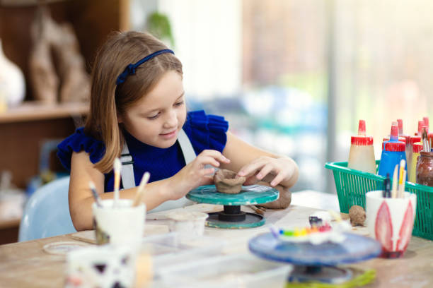 istock Child at pottery wheel. Kids arts and crafts class 1168452234