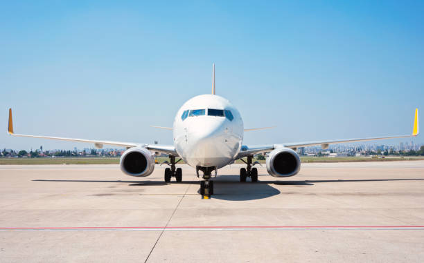 Front view of passenger airplane standing on runway. Front view of passenger airplane standing on runway. passenger boarding bridge stock pictures, royalty-free photos & images