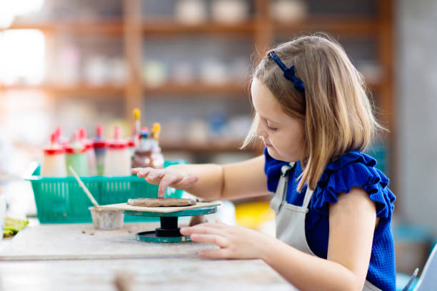 istock Child at pottery wheel. Kids arts and crafts class 1168452379
