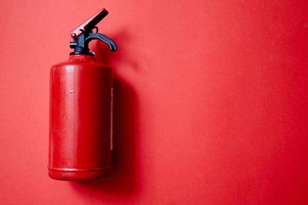 istock Fire safety, or security and protection concept. A fire extinguisher on a red background. 1168453879