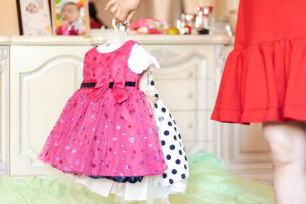 istock Female holding her daughter's new dresses 1168454910