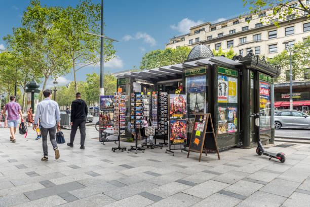 French newstand Paris, France - August 2, 2019: Tourists and passersby around a press kiosk and souvenirs in the Champs Élysées of Paris France. news stand stock pictures, royalty-free photos & images