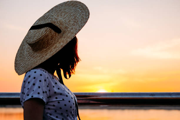 istock Woman at the sunset light wearing large straw hat 1168456758