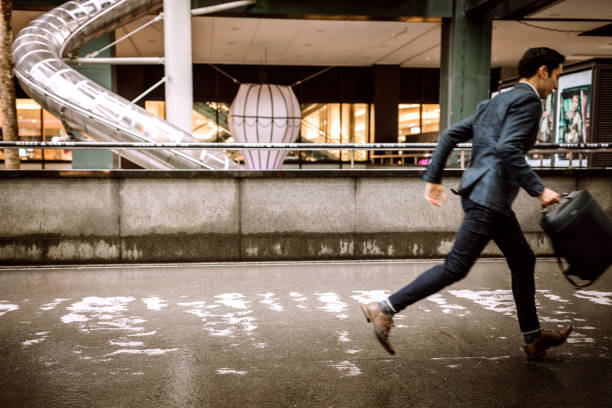 istock Businessman with bag running on sidewalk 1168459947