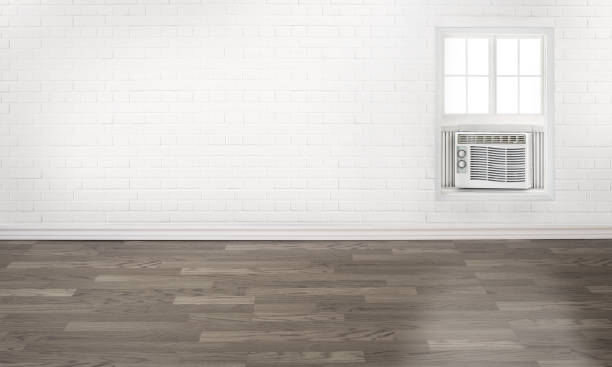 istock Air conditioner in an empty white brick wall room with a window 1168463643