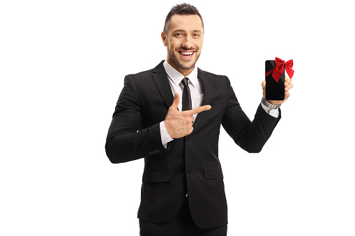 Bisinessman holding a mobile phone with a bow and pointing isolated on white background