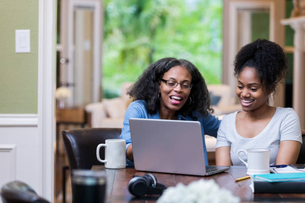 Tutor helps college student Mature African American female tutor helps a female college student study for exam. college student and parent stock pictures, royalty-free photos & images