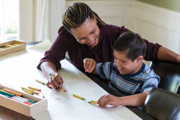 istock Young boy with Down Syndrome laughs with his mother 1168467222