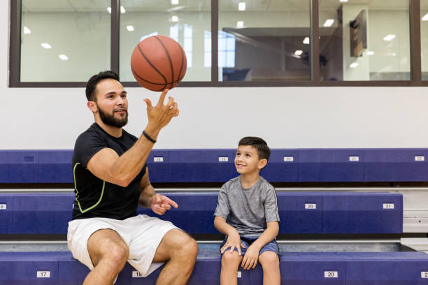 istock Uncle shows nephew how to spin ball on one finger 1168467462