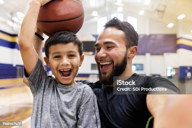 Vater Macht Selfie Während Sohn Hält Einen Basketball Auf Dem Kopf Stockfoto und mehr Bilder von Kind