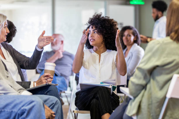 istock Two women gesture while discussing neighborhood issues at homeowner's meeting 1168467762