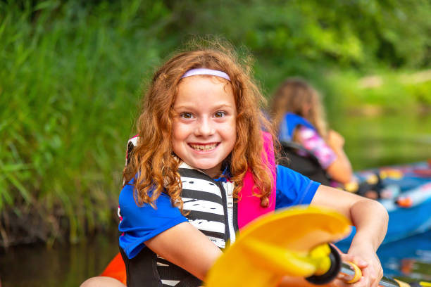 istock Girl In Kayak Holding Up Yellow Paddle 1168469046