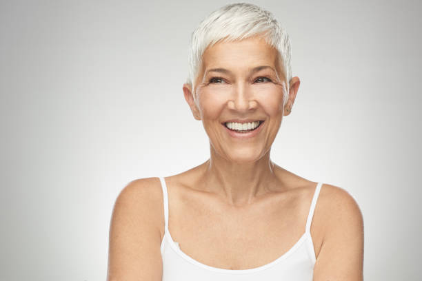 istock Senior woman posing in front of gray background. 1168470049