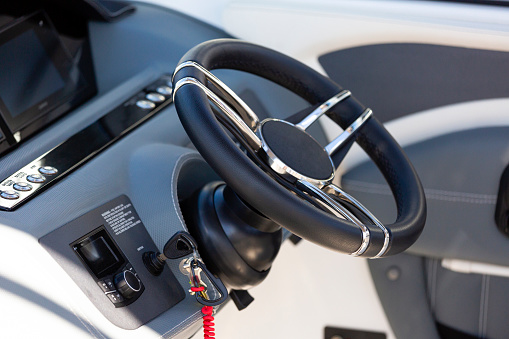 Luxury speedboat control panel with steering wheel, copy space, full frame horizontal composition